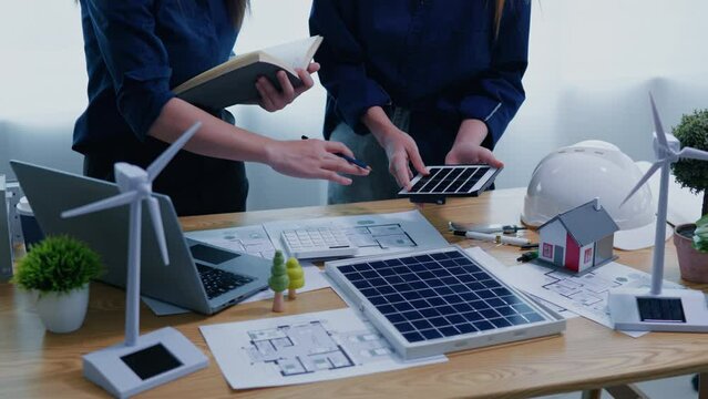 Working and brainstorming for cost estimating on paperworks and floor plan drawings about solar power energy system design to electricity and heat architectural and engineering for houses and building