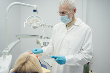 Dental doctor treating a female patient in hospital.