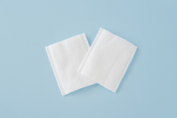 white rectangle cotton pads on blue background,  gentle and effective makeup or nail polish...