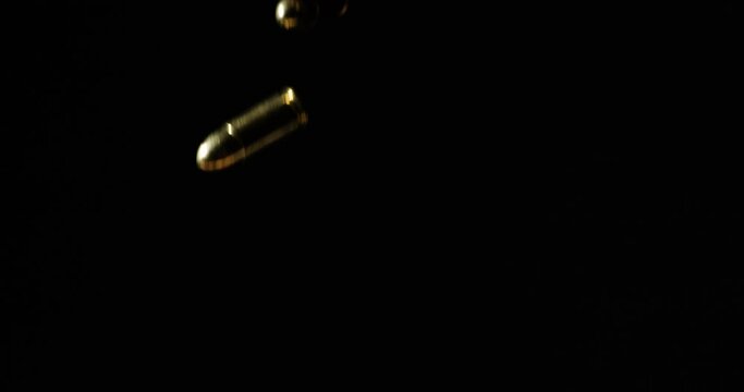 9mm Parabellum Firearms Cartridge Falling In Slow Motion, Isolated In Black Backdrop. studio shot