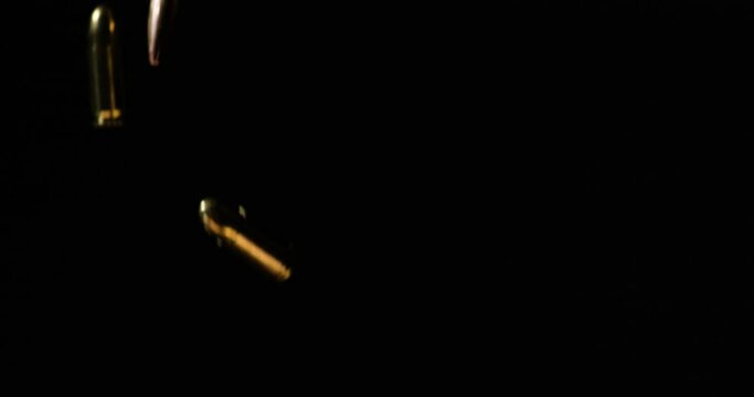 300 AAC Blackout And 9mm Luger Bullets Dropping In Slow Motion Against Black Background.