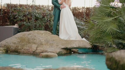 Couple by pond with rocks and garden