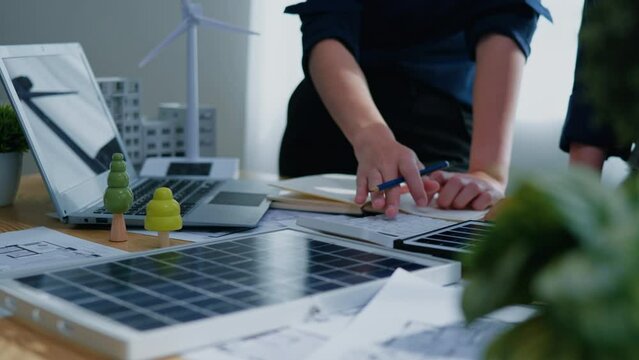 Working and brainstorming for cost estimating on paperworks and floor plan drawings about solar power energy system design to electricity and heat architectural and engineering for houses and building