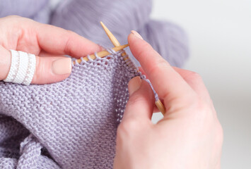 A woman knit with knitting needles