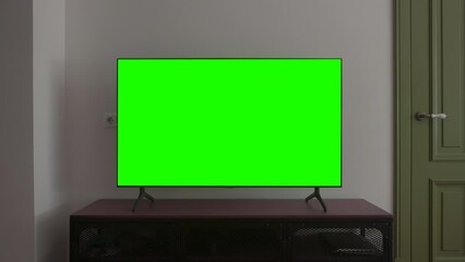 TV screen mockup background. Lcd tv monitor with blank green screen in living room while watching 