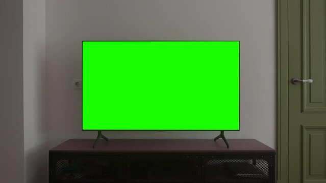 TV screen mockup background. Lcd tv monitor with blank green screen in living room while watching 