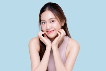Beautiful young Asian woman with healthy and perfect skin on isolated blue background. Facial and...