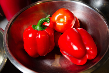 Vibrant Red Bell Peppers and Tomato in Bowl. Fresh red bell peppers and a juicy tomato in a...