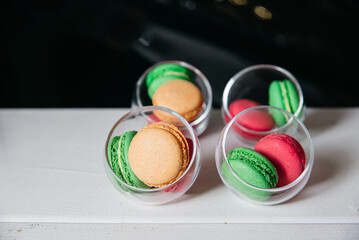 Colorful Macarons in Glass Bowls on Display. Assorted colorful macarons presented in transparent glass bowls, ideal for events and sweet tables.