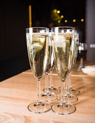 Champagne Flutes on Festive Background. Elegant champagne flutes filled with sparkling wine, ready for a celebration, with soft bokeh lights in the background.