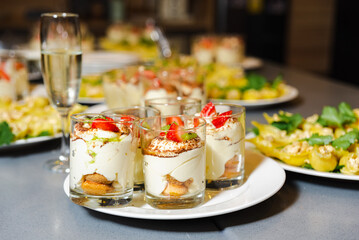 Tiramisu Dessert Cups with Fresh Strawberries. Individual tiramisu dessert cups topped with fresh strawberries and a dusting of cocoa powder, served with champagne.