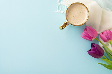 Spring flair concept. Elevated view of a frothy coffee, early spring tulips, and a woven shawl on a...
