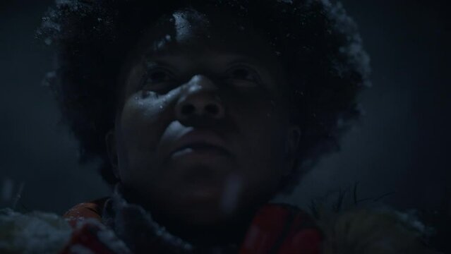 African Woman With Afro Hairstyle In Organge Clothes Outside in Strong Snowfall