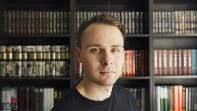 An individual stands in front of bookshelves, sharing insights or reviews about literary works.