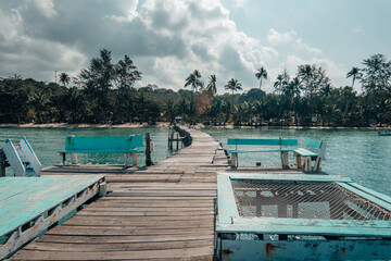 Wooden pier by the beach and clear blue water on the island