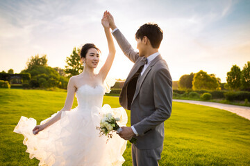 Happy bride and groom dancing on the grass