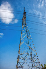 High Voltage Power Lines Towering Over Blue Sky