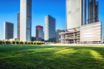 Obraz premium Sunlit Skyscrapers and Green Park in Modern City