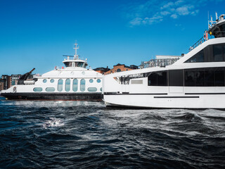 Modern ferry cruising in Oslo fjord and arriving to a city quayside