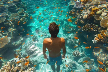 Foto op Canvas Asian man in a mask swims on a coral reef © sofiko14