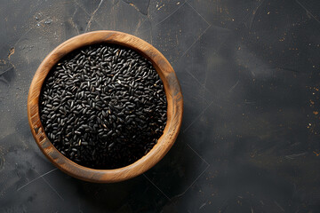 grains de riz noir dans un bol en bois d'olivier, sur un fond texturé noir avec espace négatif pour texte, copyspace - obrazy, fototapety, plakaty