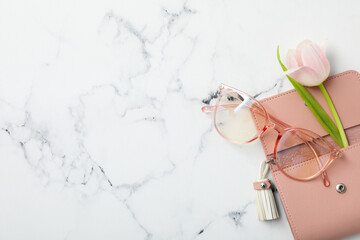 Female bag, tulip and glasses on marble background, space for text