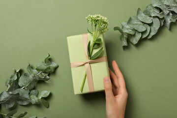 A gift with flowers on a green background.