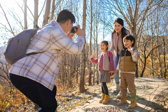 Happy young family taking photos outdoors