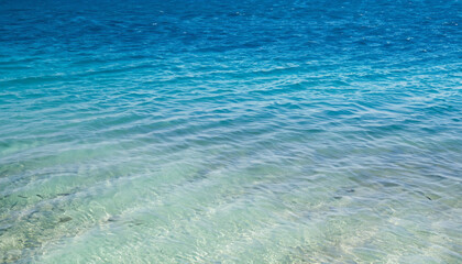 Obraz premium Ocean sea texture with calm clear water of lagoon near shore of tropical island