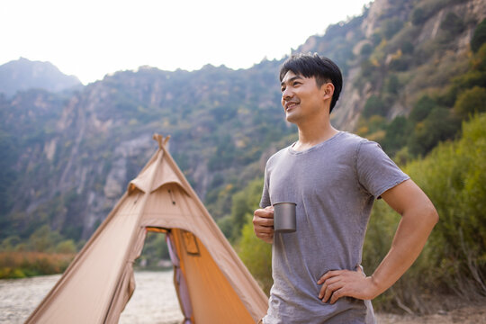 Happy young man camping outdoors
