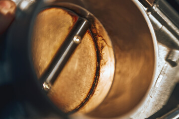 The effects of carbon on a throttle valve of a car engine. The valve blade is covered with dirt and...