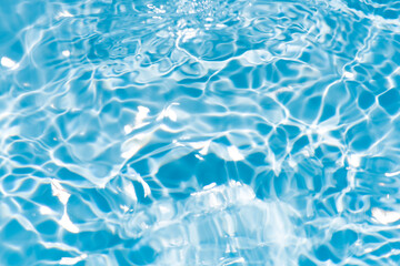 Blue water surface texture with ripples, splashes, and bubbles. Abstract summer banner background Water waves in sunlight with copy space cosmetic moisturizer micellar toner emulsion. Blue water wave