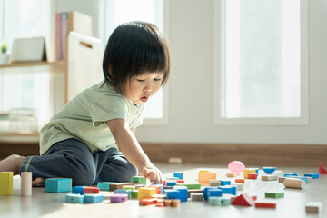 Happy Asian child playing and learning toy blocks. children are very happy and excited at home....