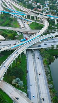 Aerial view of Interstate 95 and Florida State Route. Multilevel interchange with cars and road signs. Vertical video.