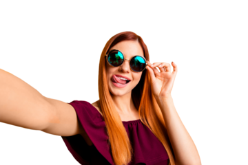 Close up portrait of  happy woman in glasses making self portrait on front camera of smartphone isolated on yellow background
