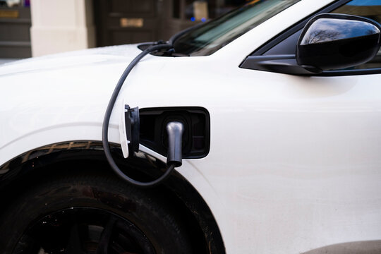 Electric plug connected to car for charging at station