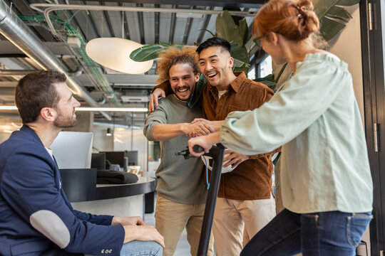 Diverse multiracial colleagues having fun at co-working space