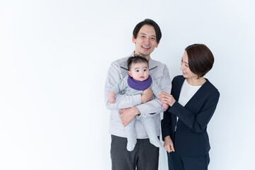 赤ちゃんを抱っこする作業着を着た男性とスーツを着た女性