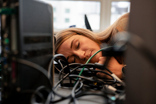 Exhausted businesswoman sleeping at desk in office