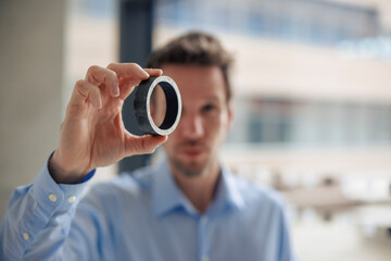 Engineer holding round metal object at workshop