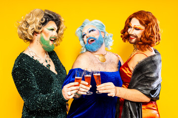 Happy drag queens toasting champagne glasses