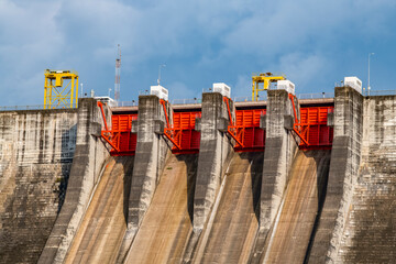 A large sluice gate blocks the water of Khun Dan Prakan Chon Dam. Beautiful large cement dam in...