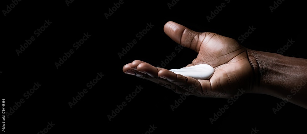 Poster captivating close-up of hands holding white cream drop and bottle in dim lighting
