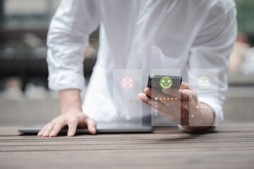 customer service evaluation and feedback rating. costumer review concept, man using phone chooses happy smiling face
