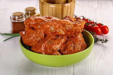 Raw turkey shoulder wing in Indian tandoori marinade