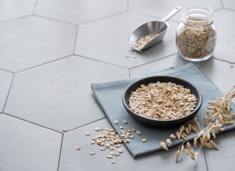 Oatmeal in a plate and in a jar on a napkin on a gray concrete tile.