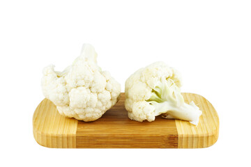 Cauliflower pieces on wooden cutting board isolated on white background