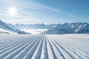 Zelfklevend Fotobehang New groomed ski piste or slope. Lines in snow with sunny mountains background. Winter skis concept.  © Straxer