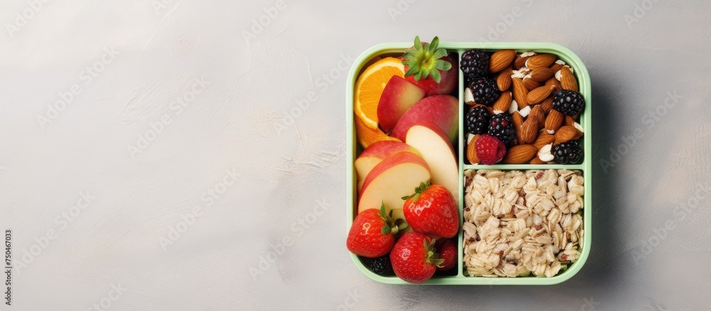Poster fresh and nutritious: green lunchbox filled with a variety of fruits and nuts