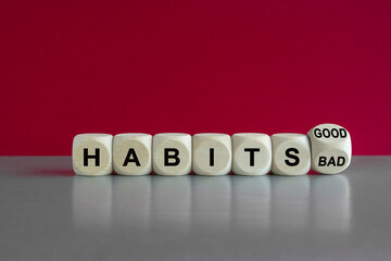 Good or bad habits symbol. Turned a wooden cube and changes words bad habits to good habits. Beautiful grey table, red background. Business, bad or good habits concept.